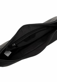 Wnętrze czarnej skórzanej torby z teksturowaną podszewką, wyposażone w kieszeń na zamek i płaską przegrodę. Zamek błyskawiczny na górze.