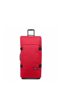 Red rolling suitcase made of sturdy fabric, featuring a retractable handle, two side clips, and a black logo on the front. Rectangular shape.