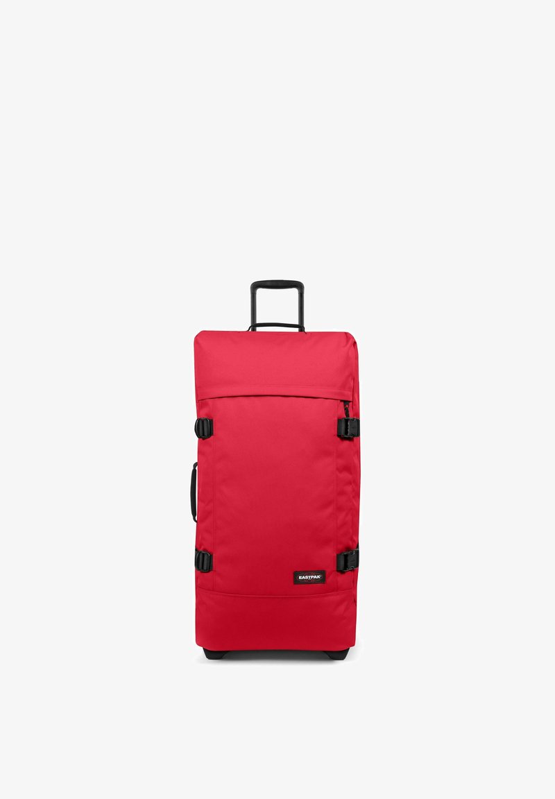 Red rolling suitcase made of sturdy fabric, featuring a retractable handle, two side clips, and a black logo on the front. Rectangular shape.