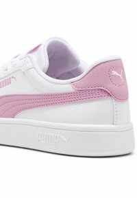 Hvide sneakers med en lyserød struktureret stribe og bagpanel. Har polstret krave, hvide snørebånd og prægede logo på hælen.