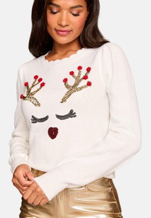 Fehér pulóver, amely szarvasarc mintával rendelkezik, arany flitteres agancsokkal, piros bojttal és csillogó piros orral, fényes arany nadrággal párosítva.