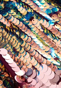 Iridescent sequin fabric with circular, reflective sequins in shades of blue, gold, and pink, arranged closely on a textured backing.