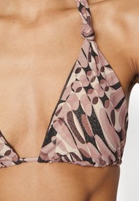 Top de biquíni triangular em tons de rosa e preto, com um padrão texturizado e alças knotadas para ajuste.
