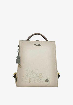 Heller beiger Leder-Rucksack mit einer strukturierten Form, ausgestattet mit einem oberen Griff und dekorativen Nähten. Enthält Anhänger-Details und Markenkennzeichnung.