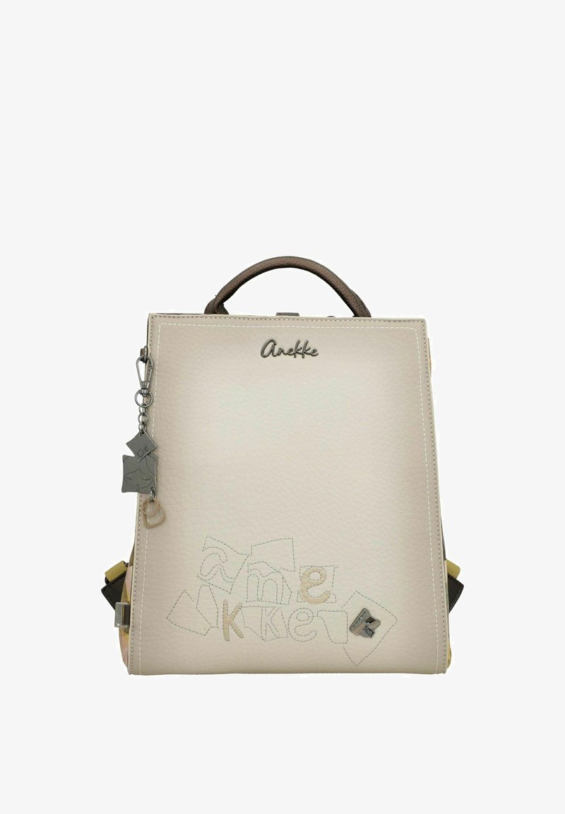 Sac à dos en cuir beige clair avec une forme structurée, doté d'une poignée supérieure et de coutures décoratives. Comprend des accents de charms et un marquage de la marque.