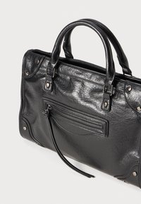 Schwarze Lederhandtasche mit strukturierter Form. Verfügt über zwei Griffe, eine vordere Reißverschlusstasche und silberne Hardware-Akzente. Strukturierte Oberfläche.