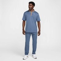 Nike polo krekls gaiši zilā krāsā ar brūnu apkakli, apvienots ar atbilstošām gaiši zilām biksēm un baltām kedām. Audums izskatās gluds.