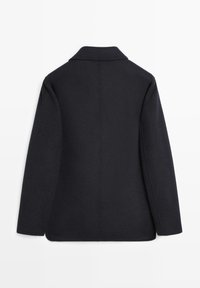 Back view of a black wool coat with a notched collar, long sleeves, and a straight cut, featuring clean lines and minimalistic design.