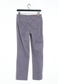 Pantaloni di cotone grigi appesi a un appendiabiti, con due tasche posteriori con dettagli di cucitura e borchie metalliche.