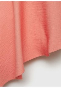 Tessuto rosa corallo con una superficie leggermente texturizzata, bordi fluttuanti e una finitura liscia. Il materiale leggero si drappeggia dolcemente.