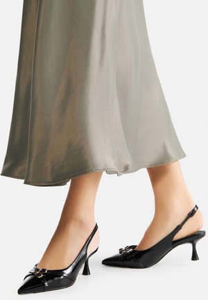 Décolleté slingback in vernice nera con punta affusolata e tacco a stiletto basso. Presentano una fibbia decorativa sul davanti.