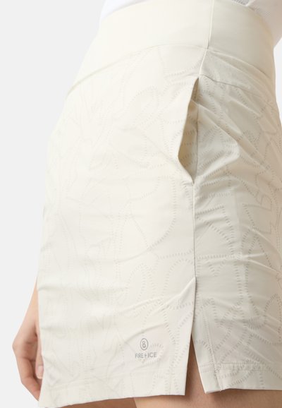Crème rok met een gestructureerd patroon van gebogen lijnen, met een zijsplit en een logo-accent dichtbij de zoom. Gladde, lichte stof.