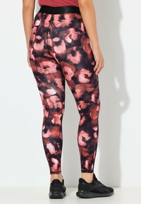 Leggings met hoge taille in een bloemenpatroon met tinten roze en donkere kleuren. Glad stof, strakke pasvorm en een zwarte tailleband.