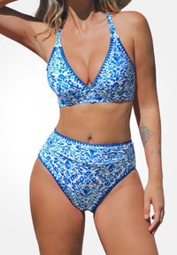 Bikini-Set mit blau-weißen Mustern, bestehend aus einem dreieckigen Bralette mit verstellbaren Trägern und hochgeschnittenen Hosen, glatte Stoffstruktur.