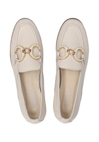 Beige leren loafers met een ronde teen, voorzien van dubbele C-vormige gouden accenten op de bovenkant en beige stiksels langs de randen.