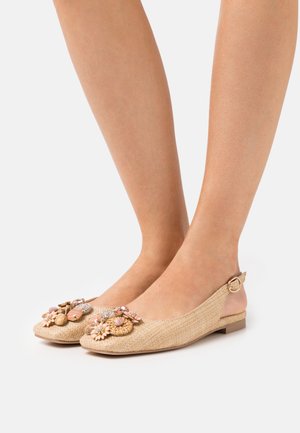 Des ballerines beiges à bride arrière avec des embellissements floraux, fabriquées dans un matériau texturé. Elles présentent une pointe arrondie et un détail de boucle sur le talon.