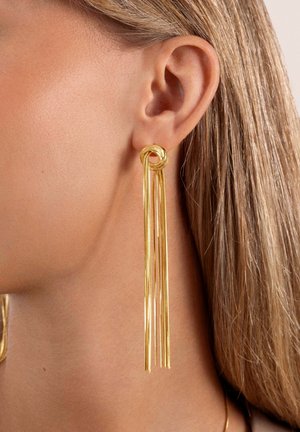 Orecchini d'oro con un design a nodo attorcigliato nella parte superiore, con più filamenti allungati che pendono verso il basso, creando un aspetto elegante e lineare.