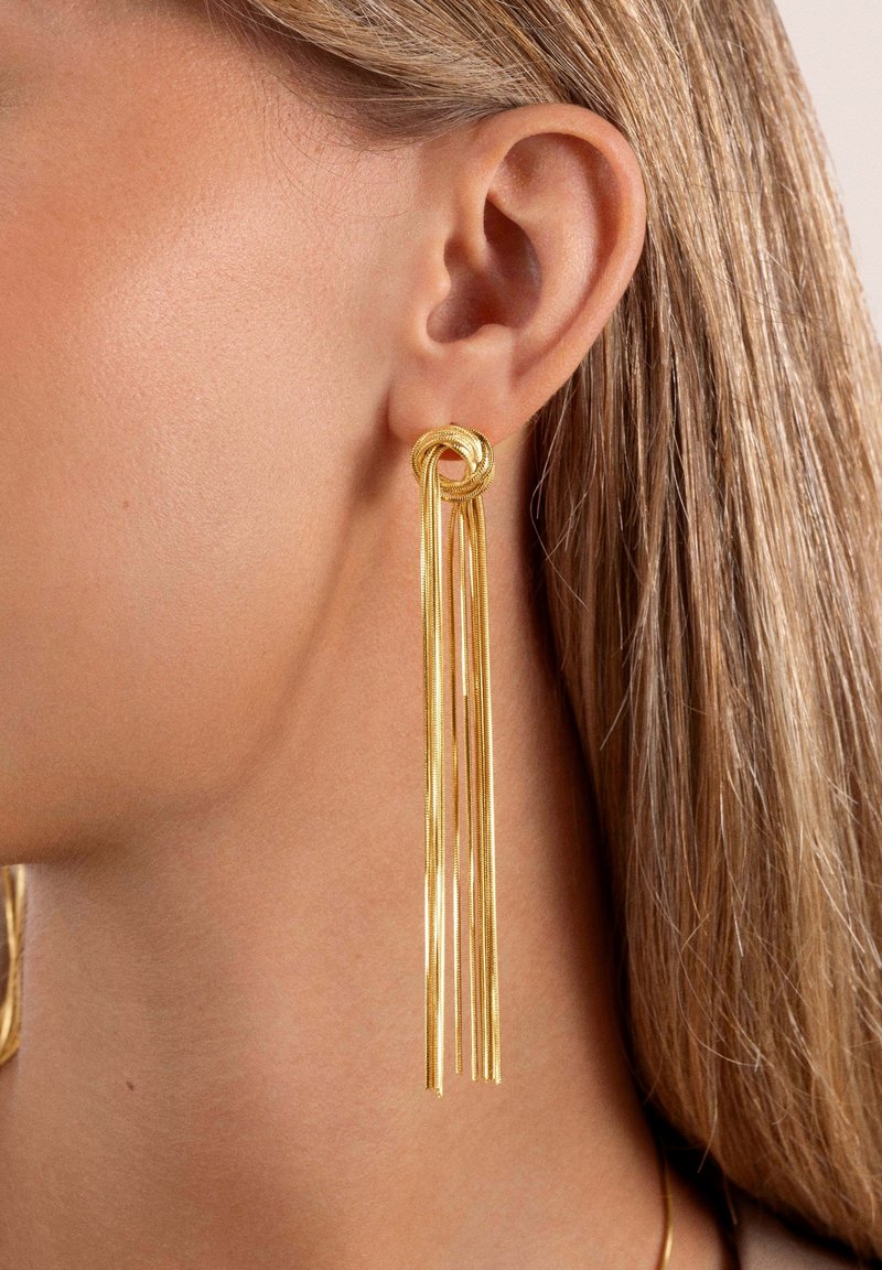 Orecchini d'oro con un design a nodo attorcigliato nella parte superiore, con più filamenti allungati che pendono verso il basso, creando un aspetto elegante e lineare.