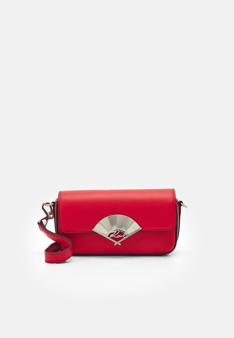 Rød læder crossbody taske med en fold-over klap, der har en sølvfarvet vifteformet accent og en aftagelig rem. Glat tekstur, kompakt design.