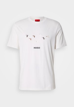 White cotton t-shirt featuring a minimalist bird graphic in various shades above the brand name "HUGO" printed in black. Short sleeves.