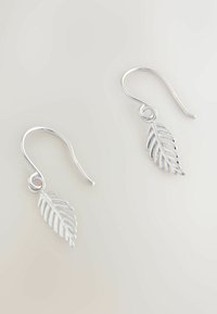 Ezüst, levél alakú fülbevalók részletes bordázott mintázattal és akasztós záródással, fényes felülettel és könnyű szerkezettel.