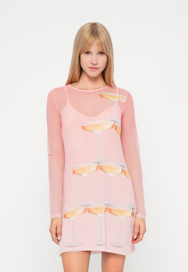 Rožinė ilgomis rankovėmis suknelė, pagaminta iš skaidraus audinio, su pakartojančiu šampano taurių raštu. Dizainas yra žaismingas ir modernus.