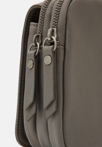 Szara skórzana torba z dwoma suwakami i przeszyciami, o gładkiej fakturze i prostokątnym kształcie.