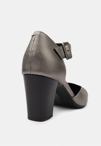 Chaussure à talons hauts en cuir gris avec un bout arrondi, une bride de cheville ajustable et un épais talon noir. Texture lisse avec des coutures délicates.