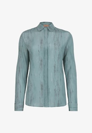 Ljusblå blus med ett subtilt vertikalt randmönster, långa ärmar och krage. Tillverkad i ett smidigt, lätt tyg.