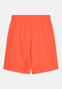 Costume da bagno arancione brillante con un elastico in vita. Tessuto liscio, taglio fino al ginocchio e senza tasche visibili o motivi.