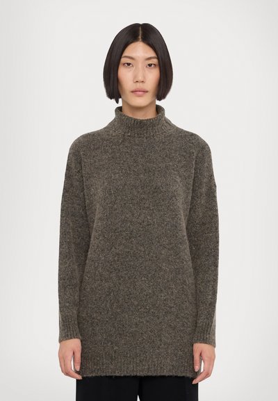 Pull en tricot noir surdimensionné avec un col montant, des poignets et un ourlet côtelés. Texture douce et coupe décontractée. Manches longues et design minimaliste.