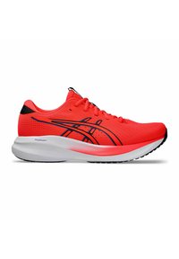 Baskets de sport rouges avec une tige en mesh, accents noirs, semelle blanche rembourrée et lacets. Présente un design épuré pour la performance.