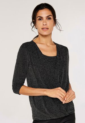 Zwarte, gestructureerde blouse met driekwartmouwen, vierkante halslijn en een geplooide accent bij de taille, met subtiele metallic draadjes.