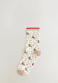 Sock with beige leopard spots, green holly leaves, red berries, tan heel and toe, and red cuff on a light grey background.