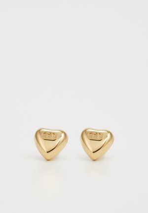 Boucles d'oreilles en forme de cœur en or avec une texture lisse, présentant un logo gravé sur la surface. Design simple et taille compacte.