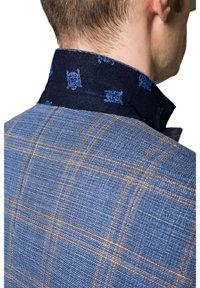 Czarny blazer w niebieskim materiale w kratę z brązowymi liniami; kołnierz wykonany z ciemnoniebieskiego materiału z subtelnym, skomplikowanym wzorem.