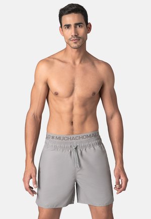 Gray swim shorts made of lightweight material, featuring an elastic waistband with drawstring and a logo detail.