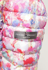 Färgglad puffjacka med ett blommönster i rosa, blått och gult. Inkluderar en grå märkestagg med "Frieda Freddies New York."