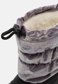 Lilla, teksturert overdel med en samlet design og svarte detaljer. Myk, kremfarget foring; justerbar snøring øverst. Svart såle.