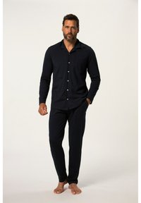 Ensemble de pyjama en coton bleu marine avec manches longues et col. Comprend une poche poitrine et des boutons, assorti à un pantalon. Texture lisse.