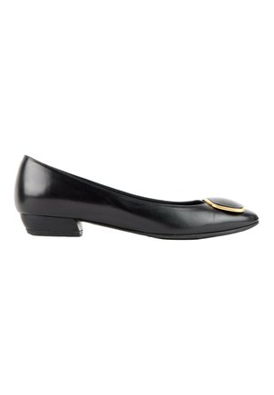 Ballerine noire en cuir à petit talon, avec un bout rond et un ornement circulaire bordé d’or sur le dessus.