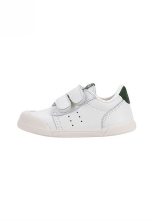 Zapato blanco de cuero con dos tiras de Velcro, acento de ante verde en el talón, suela de goma, detalles perforados en el costado, diseño casual de perfil bajo.