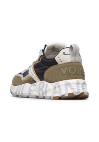 Sneaker med en strukturerad olivgrön mocka och överdel i svart nylon. Har en kraftig vit sula med grå och bruna accenter, samt "VOILE BLANCHE"-text.