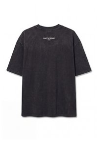 Μαύρο oversized T-shirt με κοντά μανίκια και μικρό λευκό κείμενο "ESCAPE THE ORDINARY" κοντά στον πάνω λαιμό πίσω.