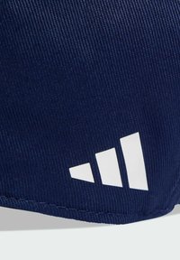 Pantalones cortos azul marino hechos de una tela texturizada, con un logo blanco que presenta tres rayas diagonales. El dobladillo está cosido, garantizando durabilidad.