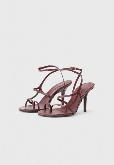 Bordeaux sandály na vysokém podpatku se řemínkovým designem, s texturovanou podrážkou, otevřenou špičkou a nastavitelným páskem kolem kotníku se zlatou sponou.