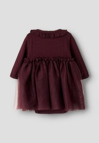 Robe bordeaux à manches longues, haut texturé et taille volantée. Le bas présente une superposition de tulle transparent pour plus de volume. Encolure froncée.