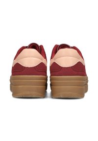 Rote Wildleder-Sneaker mit einem hellrosa Lederakzent und einer klobigen braunen Gummisohle. Rundliche Form mit strukturierten Details im Obermaterial.