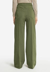 Gröna vida byxor med hög midja, tillverkade av mjuk tyg. Har två bakfickor och en ren, minimalistisk design.