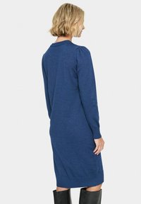 Abito maglione in blu scuro, con maniche lunghe, collo a coste e orlo aderente. Texture morbida e design semplice.